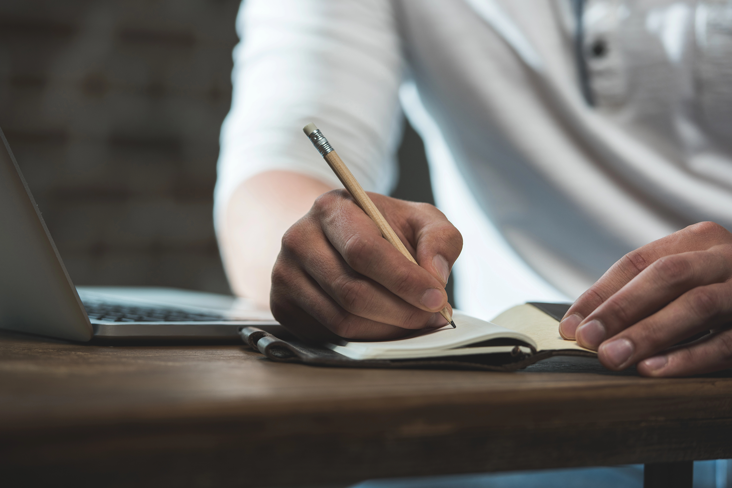 Image of a man writing in a journal